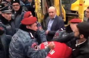 Как полицейский руками и ногами избивает демонстранта (видео)